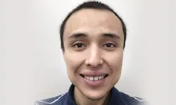 Smiling person with short hair, facing forward.