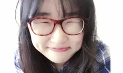 Smiling person with glasses and plaid shirt.