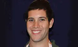 Smiling person against a dark background.