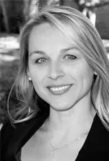 Smiling woman in outdoor setting, black and white.