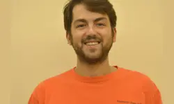 Smiling man in an orange shirt.