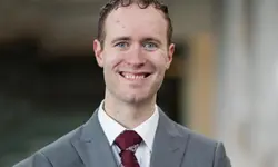 Smiling man in a suit and tie.