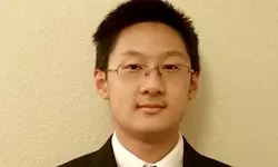 Young man wearing glasses and a suit.