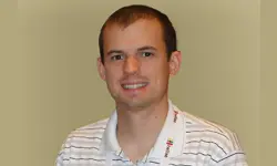 Smiling man wearing a striped shirt.