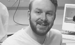 Smiling man sitting in front of computer.