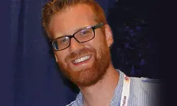 Smiling man with glasses and red beard.