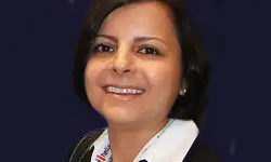 Smiling person with short hair and dark background.