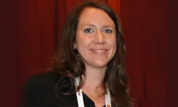 Smiling woman against a dark red background.