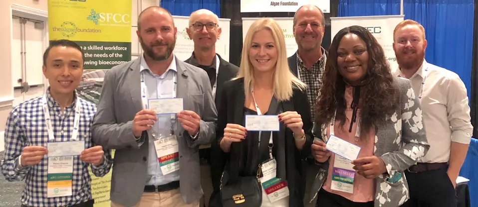 Group of people holding certificates at event.
