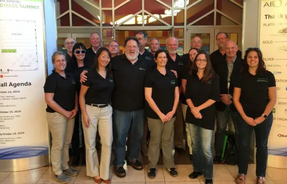 Group photo of people in casual and business casual attire indoors.