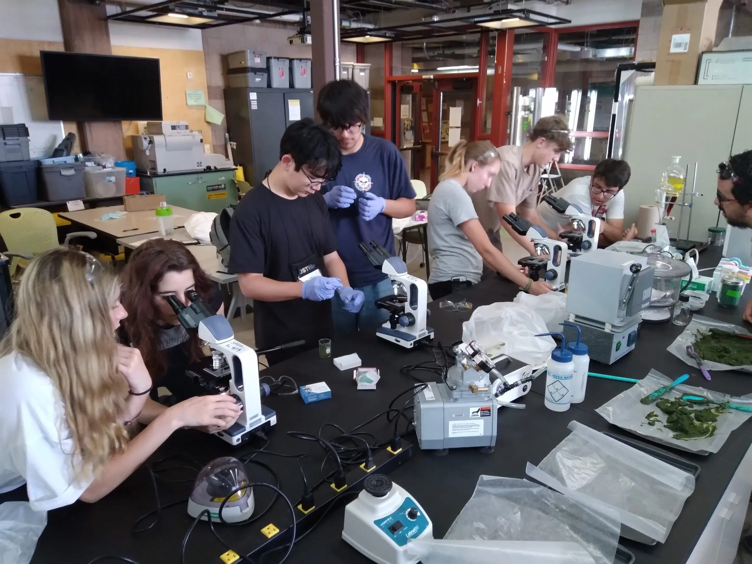 People working on assembling or repairing electronic devices in a workshop.
