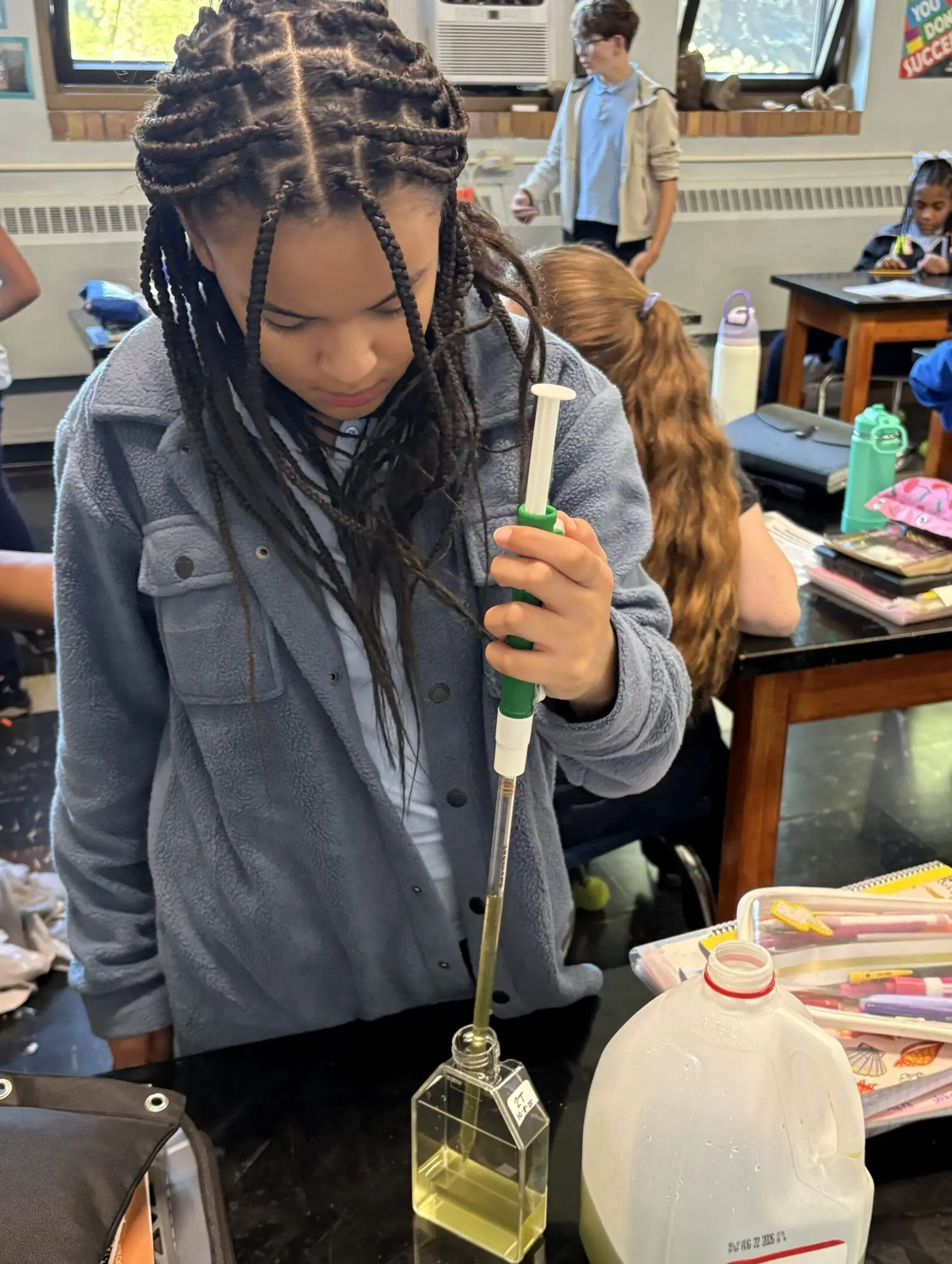 A student uses a pipette during a science experiment in class.