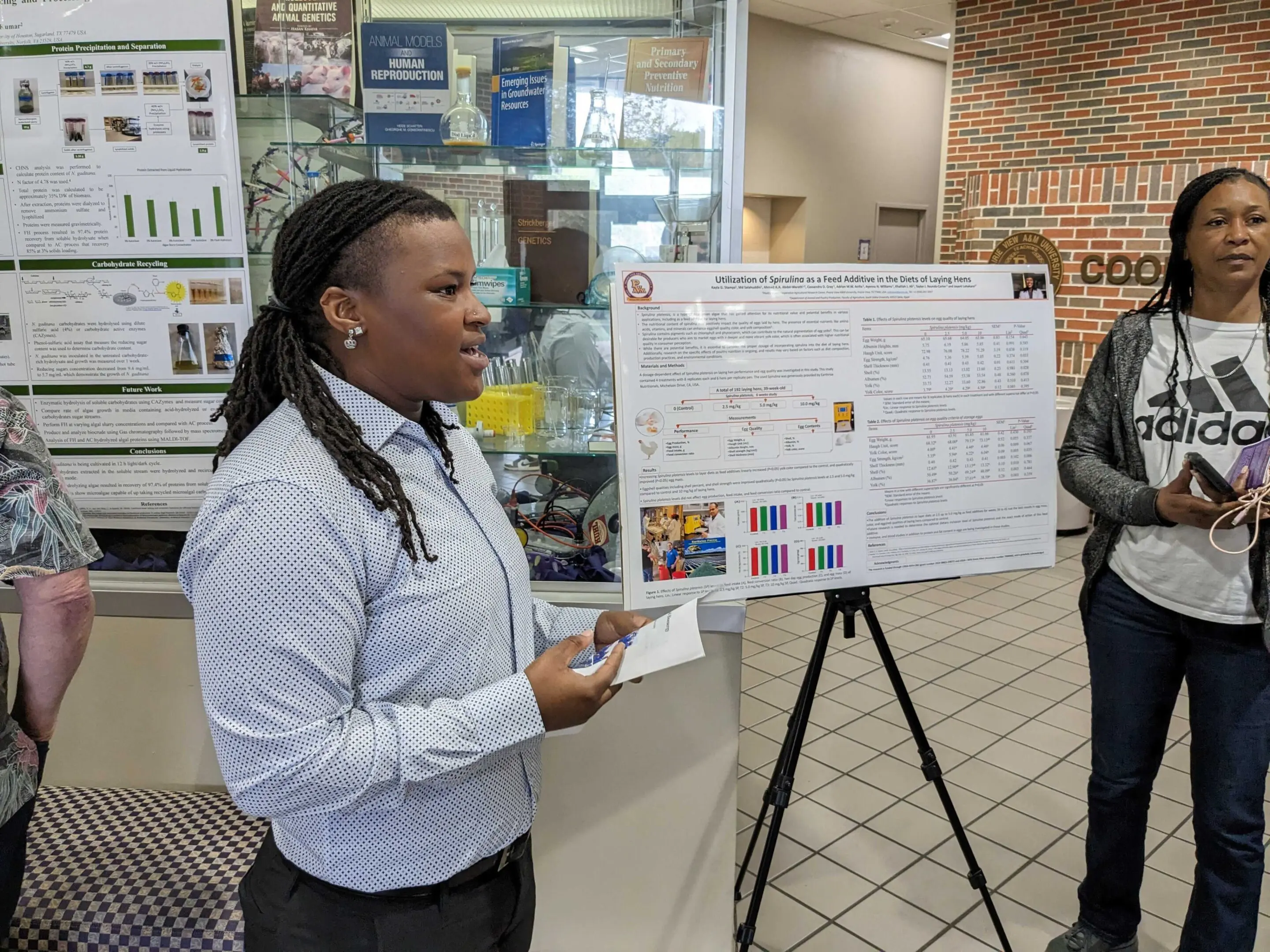 A person presenting research on a poster board in a public space.
