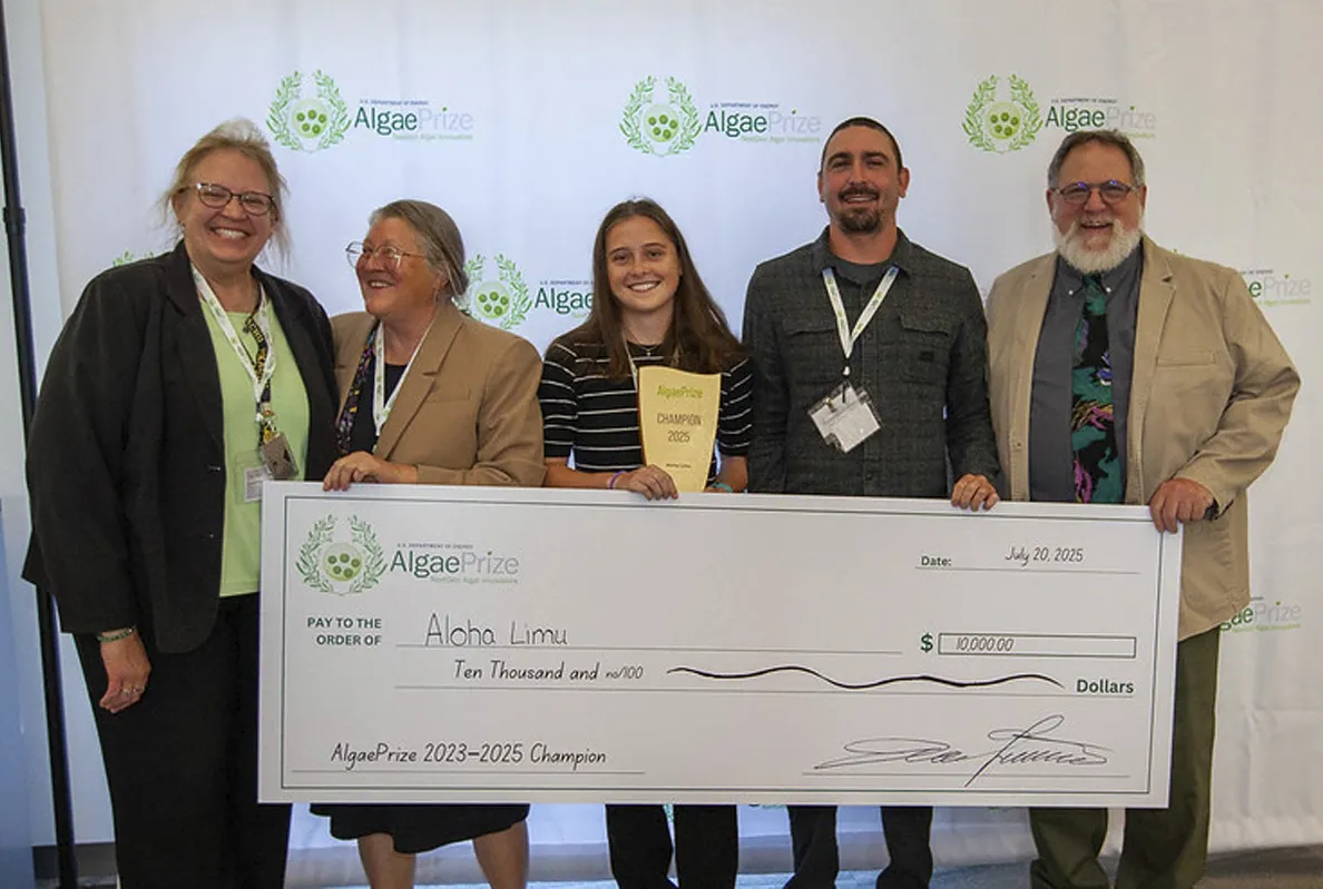 Group of five people holding a large award check and smiling.