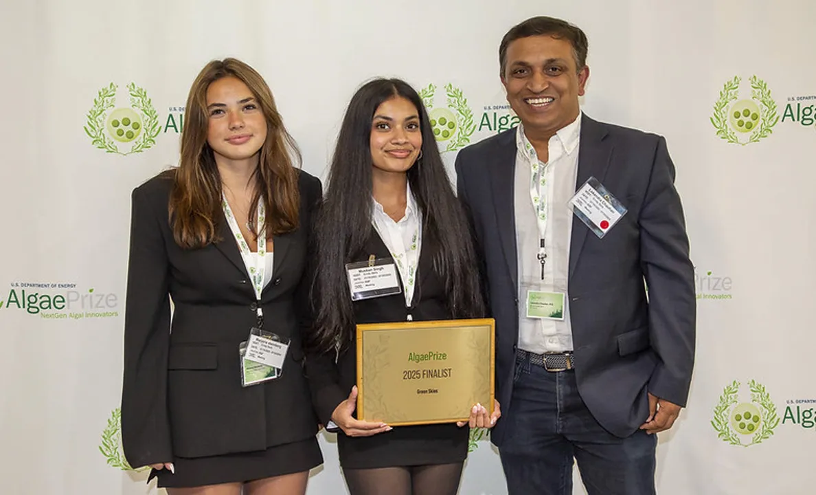 Three professionals at a conference, one holding a certificate.