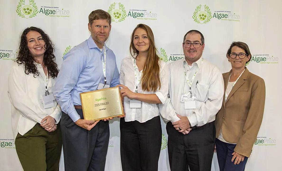 Three people holding a certificate at an event.